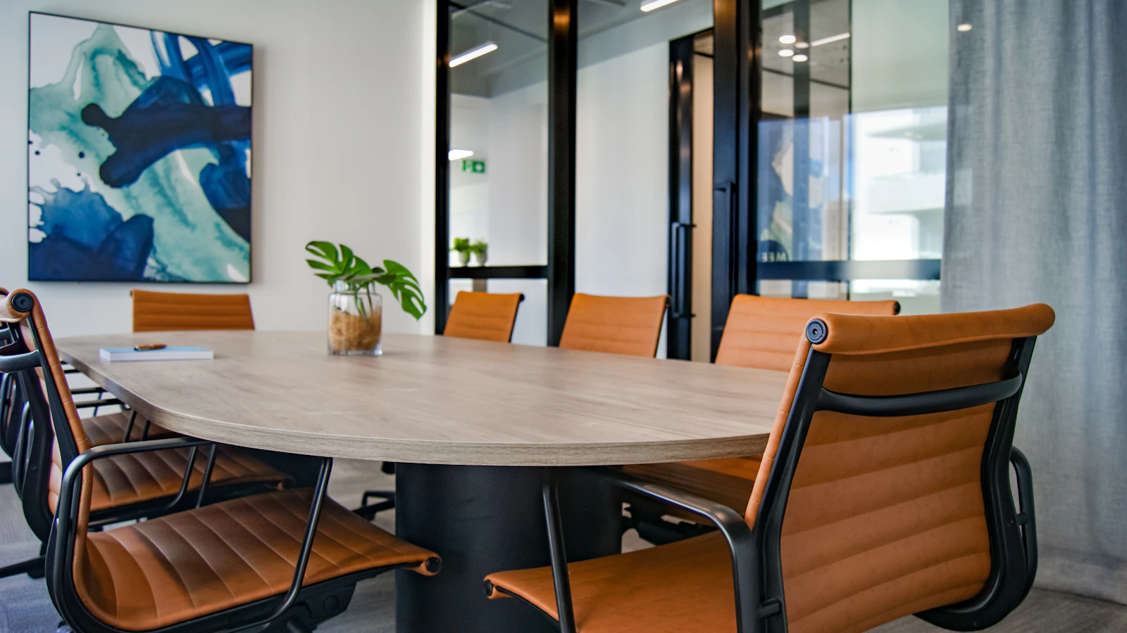 A meeting room with a long table and leather chairs