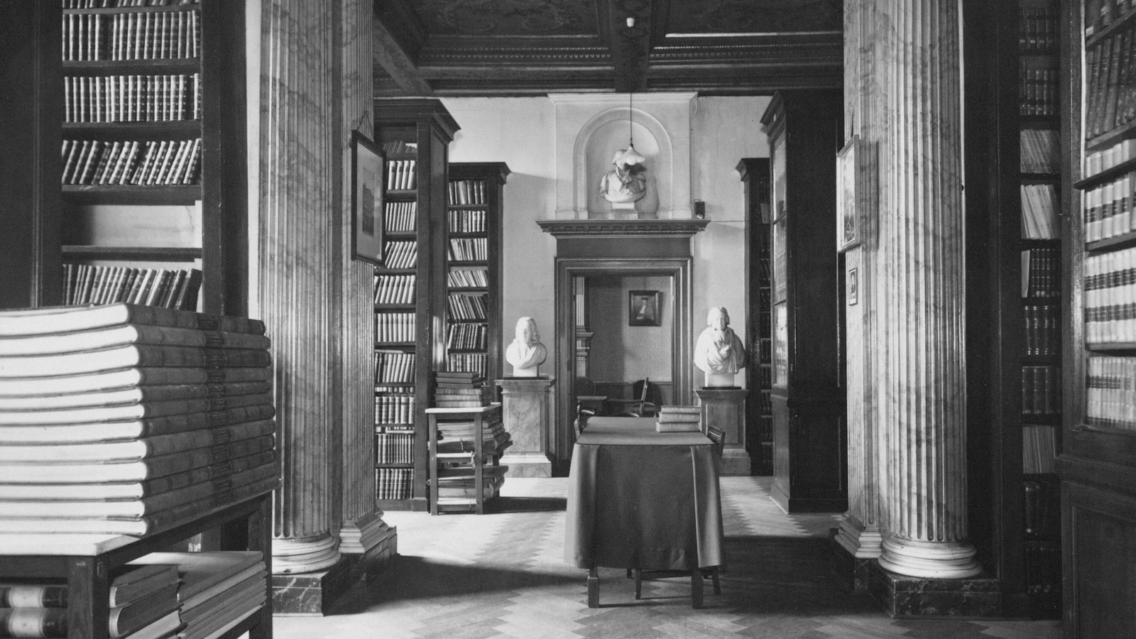 An old university library with busts and tall shelves